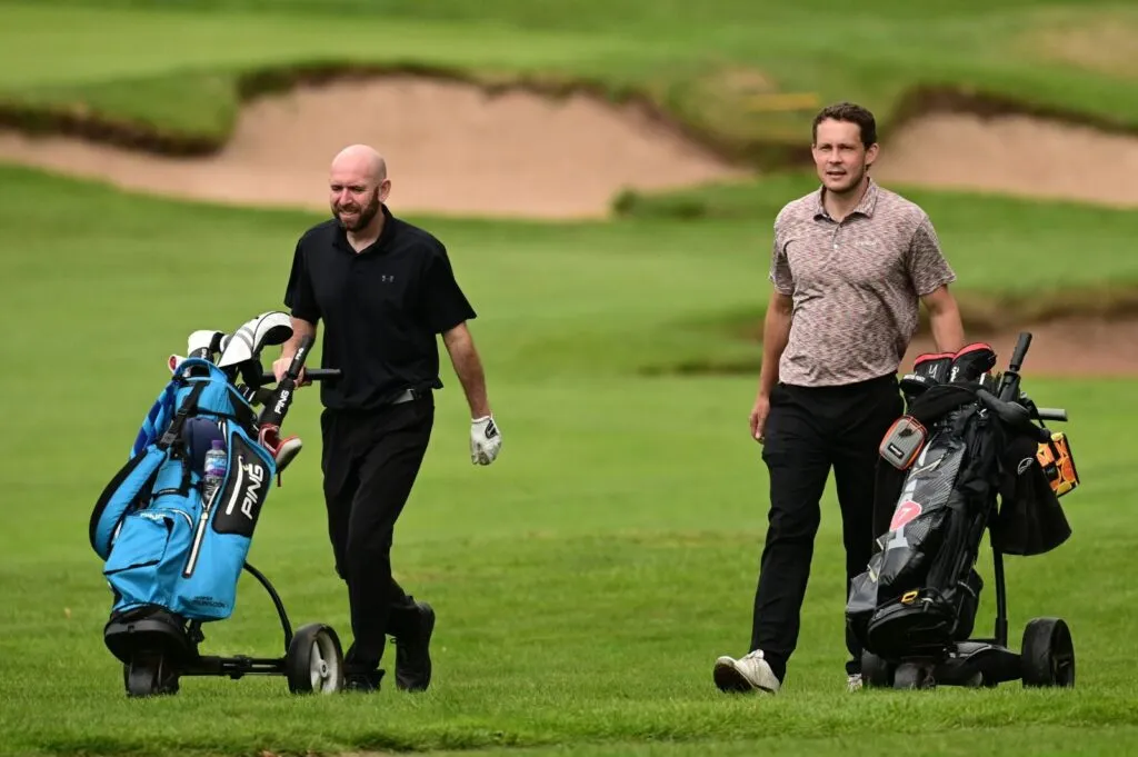 Tim Ford on the left and Chris Crowder on the right walking the course with their golf trolleys at the PGA 4Ball Professional National Championship at Carden Park.
